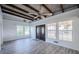 Bright living room featuring beamed ceiling, gray flooring and natural light from windows near the entry at 827 Sherwood Dr, Lake Wales, FL 33898