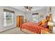 Cozy bedroom featuring two windows, a ceiling fan, carpet flooring, and a bed at 860 Lila St, Bartow, FL 33830