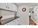 Bright hallway with white cabinets and dark countertops leading to a bedroom with a patterned rug at 860 Lila St, Bartow, FL 33830