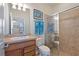 Well-lit bathroom featuring a glass-enclosed shower, a toilet, and a sink with a wooden vanity at 8718 Rindge Rd, Polk City, FL 33868