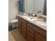 Bathroom featuring double sinks with granite countertops and wooden cabinets at 8718 Rindge Rd, Polk City, FL 33868