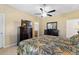 Cozy bedroom with a TV on dresser, ceiling fan, and view into ensuite bathroom at 8718 Rindge Rd, Polk City, FL 33868