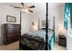 Inviting bedroom showcases a four-poster bed, a dark wood dresser, and soft lighting for a restful retreat at 8718 Rindge Rd, Polk City, FL 33868