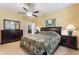 Comfortable bedroom featuring a ceiling fan, bedside lamps, and a decorative painting at 8718 Rindge Rd, Polk City, FL 33868