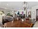 Open-concept dining room leading to living area, featuring modern light fixture and aquarium at 8718 Rindge Rd, Polk City, FL 33868