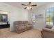 Comfortable living room with neutral tones, ceramic tile flooring, and natural light from a large window at 8718 Rindge Rd, Polk City, FL 33868