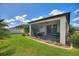 A screened-in porch with outdoor seating, offering a great view of the landscaped yard at 8718 Rindge Rd, Polk City, FL 33868