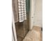 Shower with glass door, neutral tile surround and a fluffy white rug at 8718 Rindge Rd, Polk City, FL 33868