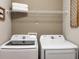 Bright laundry room featuring new Samsung washer and dryer and ample shelf space for storage at 1037 Mountain Flower Ln, Davenport, FL 33837