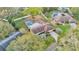 Aerial view of home showing the screened pool, mature trees, and well-maintained lawn at 1047 Sugartree S Ln, Lakeland, FL 33813