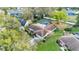 An aerial view showcasing a home with a screened pool, landscaped yard, and mature trees at 1047 Sugartree S Ln, Lakeland, FL 33813