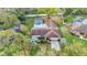 Aerial view of home showcasing screened pool, mature trees, and well-manicured landscaping at 1047 Sugartree S Ln, Lakeland, FL 33813