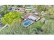 Aerial view showcasing the home with screened pool, lush landscaping, and manicured lawn at 1047 Sugartree S Ln, Lakeland, FL 33813