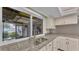 Close-up of a kitchen featuring a stainless steel sink, granite countertops, and outdoor view at 1047 Sugartree S Ln, Lakeland, FL 33813