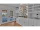 Wet bar with mirrored shelves, white cabinetry, and a view of the outside pool at 1047 Sugartree S Ln, Lakeland, FL 33813