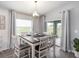 Bright dining room features modern lighting, gray wood floors and sliding door access to patio at 1108 Mountain Flower Ln, Davenport, FL 33837