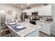 Modern kitchen featuring white cabinets, stainless steel appliances, and a large island with seating at 1108 Mountain Flower Ln, Davenport, FL 33837