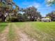 Large backyard with mature trees and a long driveway leading up to the house and shed at 116 S Lanier Ave, Fort Meade, FL 33841