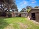 Backyard view featuring a house and an old wooden storage shed at 116 S Lanier Ave, Fort Meade, FL 33841