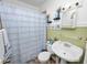 Traditional bathroom featuring a pedestal sink, a shower with blue curtain and tiled floor at 116 S Lanier Ave, Fort Meade, FL 33841