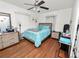 Bedroom with hardwood floors, ample natural light, and a comfortable bed with turquoise accents at 116 S Lanier Ave, Fort Meade, FL 33841