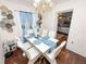 Bright dining room featuring wood floors, a modern chandelier, and white furniture at 116 S Lanier Ave, Fort Meade, FL 33841