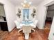 Dining room featuring wood floors, a modern chandelier, and white furniture with seating for six at 116 S Lanier Ave, Fort Meade, FL 33841