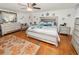 Bright and airy bedroom featuring hardwood floors, a ceiling fan, and a comfortable king-size bed at 116 S Lanier Ave, Fort Meade, FL 33841