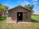 Exterior view of a wooden storage shed on a large, grassy lot at 116 S Lanier Ave, Fort Meade, FL 33841