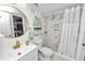 Bright bathroom featuring a tub-shower combo with updated tile and modern fixtures and shelving at 141 Fernery Rd # C-6, Lakeland, FL 33809