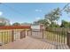 Backyard wooden deck overlooking a grassy yard and detached garage with a red fence surrounding the property at 1539 E Fern Rd, Lakeland, FL 33801