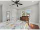 Cozy bedroom featuring hardwood floors, ceiling fan, natural light and antique dresser at 1539 E Fern Rd, Lakeland, FL 33801