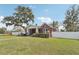 Charming home featuring a brick exterior, mature landscaping, white picket fence, and large trees at 1539 E Fern Rd, Lakeland, FL 33801