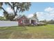 Beautiful home featuring brick exterior, white fence, manicured lawn, and mature landscaping at 1539 E Fern Rd, Lakeland, FL 33801