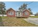 Charming brick home featuring a well-maintained lawn, wooden front porch, and a bright green front door at 1539 E Fern Rd, Lakeland, FL 33801