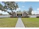 Beautiful brick home features a green door, white columns, manicured front yard, and mature trees at 1539 E Fern Rd, Lakeland, FL 33801