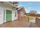 Exterior view of a brick home with a green door and a wood porch featuring a driveway to the side at 1539 E Fern Rd, Lakeland, FL 33801