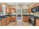 Bright kitchen featuring wooden cabinets, granite counters, and stainless steel appliances at 1539 E Fern Rd, Lakeland, FL 33801