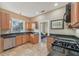 Charming kitchen featuring wood cabinets, granite countertops, tile floors, and stainless steel appliances at 1539 E Fern Rd, Lakeland, FL 33801