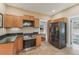 Well-lit kitchen with wood cabinetry, granite countertops, stainless steel appliances, and tile flooring at 1539 E Fern Rd, Lakeland, FL 33801