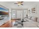 Bright living room with hardwood floors, a comfortable sectional, built-in shelving, and a ceiling fan at 1539 E Fern Rd, Lakeland, FL 33801