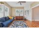 Cozy living room with a blue couch, patterned rug, hardwood floors, and large windows for natural light at 1539 E Fern Rd, Lakeland, FL 33801