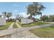 Property featuring a long driveway, detached garage, partially fenced yard, and large shade tree at 1539 E Fern Rd, Lakeland, FL 33801