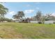 Spacious yard features green grass, mature trees, and white picket fence surrounding a brick home at 1539 E Fern Rd, Lakeland, FL 33801