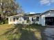 Quaint single-story home featuring a front yard with mature trees and an attached garage at 1560 Imperial Ave, Bartow, FL 33830