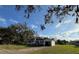 A charming single-story house with an attached garage, set against a bright sky with scattered clouds at 1560 Imperial Ave, Bartow, FL 33830