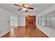 Living room featuring hardwood floors, dual ceiling fans, and an inviting brick fireplace at 1702 Valencia Blvd, Bartow, FL 33830