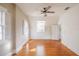 Bright bedroom features hardwood floors, ceiling fan, and sun-filled windows at 1819 Pawnee Trl, Lakeland, FL 33803