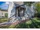 Exterior staircase leading to the home's entrance with a wooden railing and brick accent at 1819 Pawnee Trl, Lakeland, FL 33803