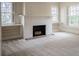 Living room with a decorative white brick fireplace and mantle flanked by built-in shelving and windows at 1819 Pawnee Trl, Lakeland, FL 33803